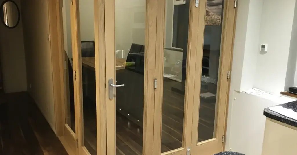 Oak-framed glazed internal doors separating a kitchen from an adjoining room.